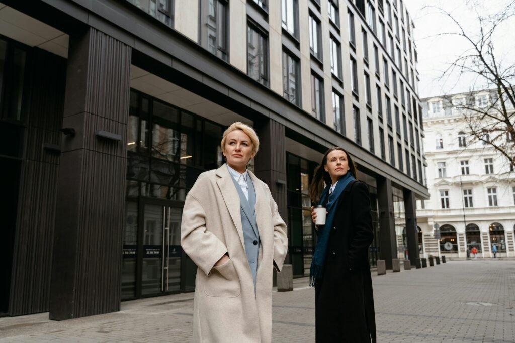 Two executive women walking confidently in the street, symbolizing empowerment, leadership, and breaking barriers