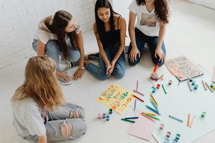 Group of young women joyfully engaged in a fun activity, symbolizing empowerment, unity, and the strength of women’s voices