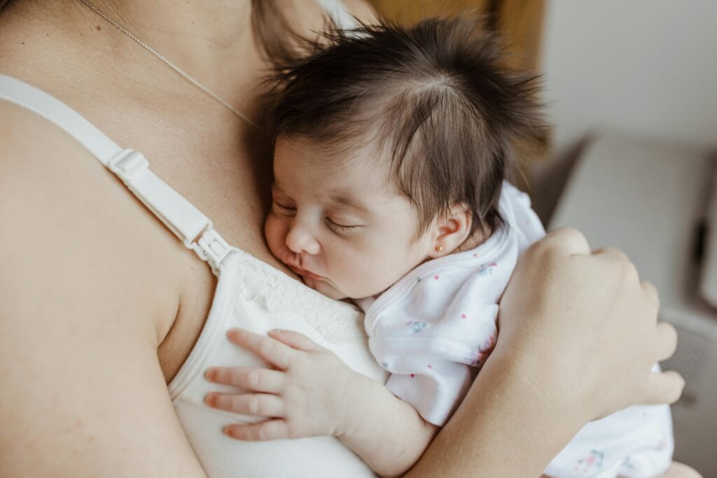 Child resting peacefully on her mother’s chest, symbolizing warmth, safety, and the deep bond of love