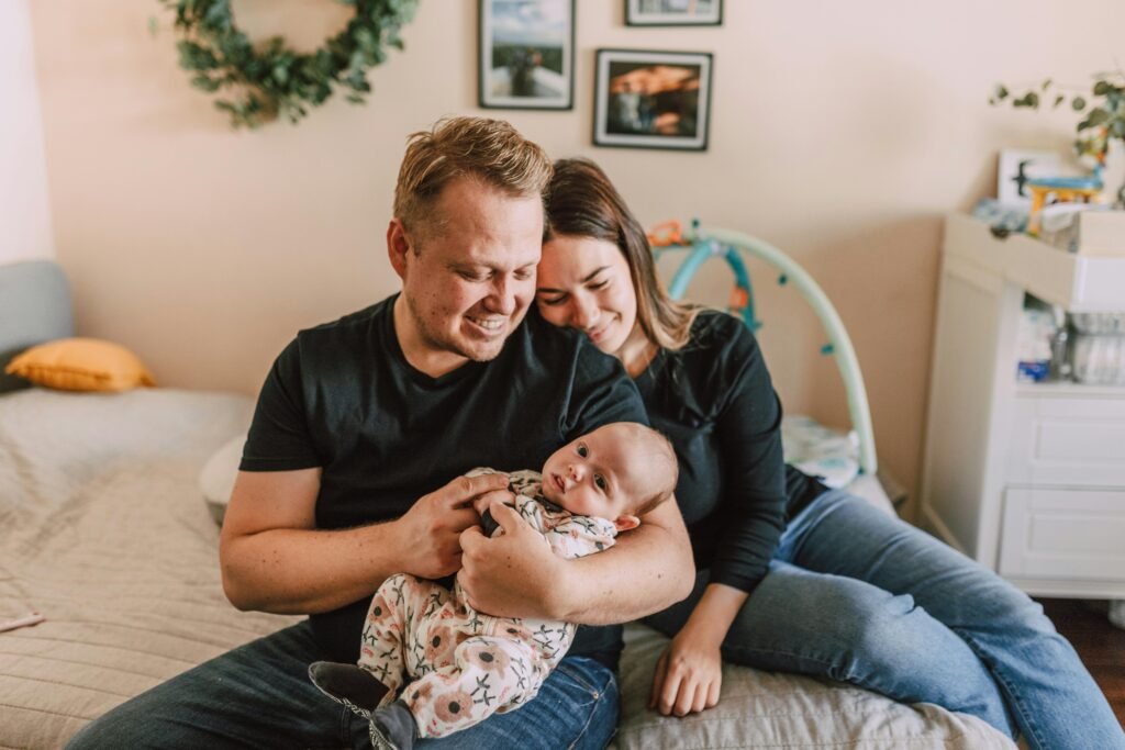 Dad holding child in his arm with mom resting on his shoulder, highlighting nurturing family connection