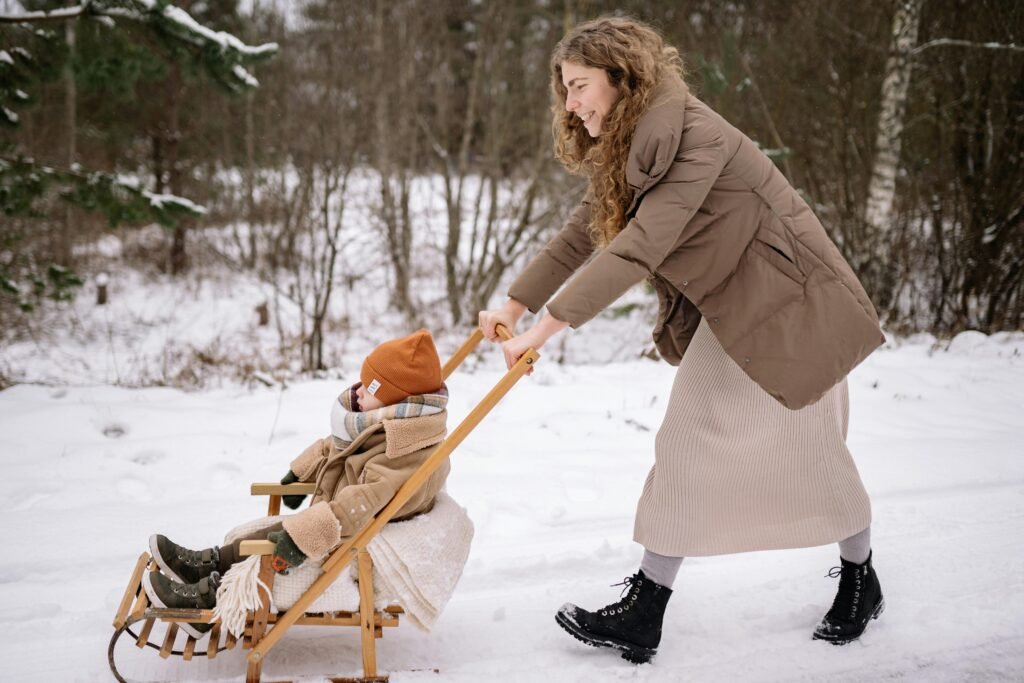 Mother pushing baby in stroller during winter, ensuring warmth and safety outdoors