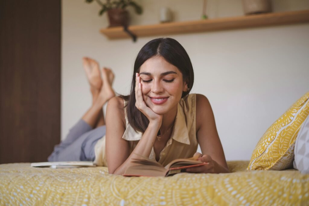 Mother reading a book while resting comfortably in bed
