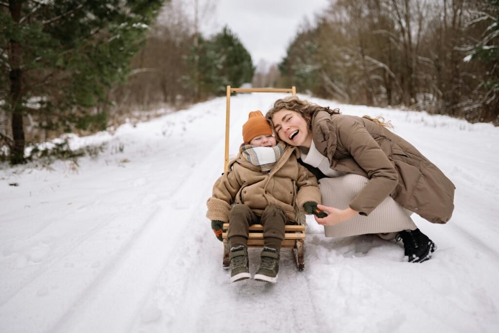 Mother caressing her child in a stroller during winter showing warmth and care
